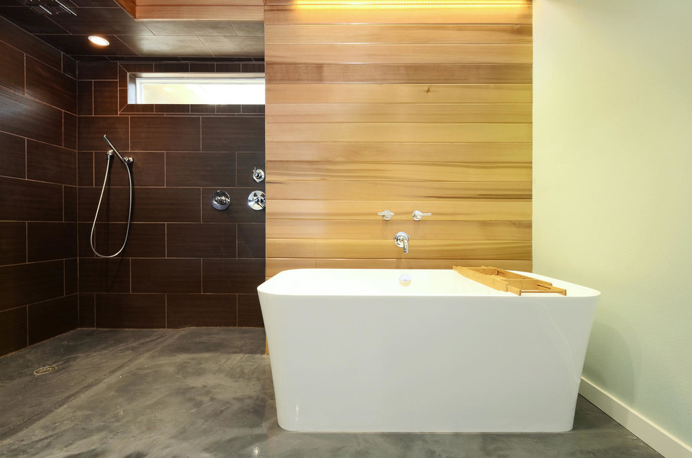 Inredning av ett modernt stort en-suite badrum, med ett undermonterad handfat, släta luckor, grå skåp, ett fristående badkar, en öppen dusch, en toalettstol med separat cisternkåpa, brun kakel, keramikplattor, gröna väggar, betonggolv och bänkskiva i betong