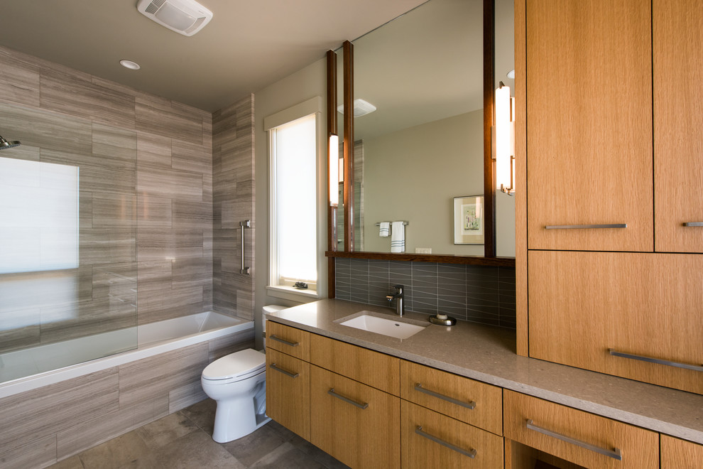 Bathroom - large contemporary master gray tile and mosaic tile travertine floor and beige floor bathroom idea in Other with flat-panel cabinets, light wood cabinets, a two-piece toilet, beige walls, an undermount sink and quartz countertops