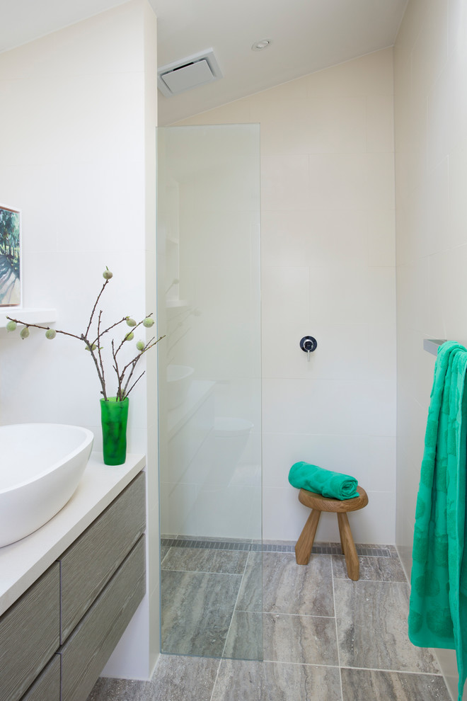 Imagen de cuarto de baño contemporáneo con armarios con paneles lisos, puertas de armario grises, ducha abierta, paredes beige, aseo y ducha, lavabo sobreencimera, suelo gris y ducha abierta