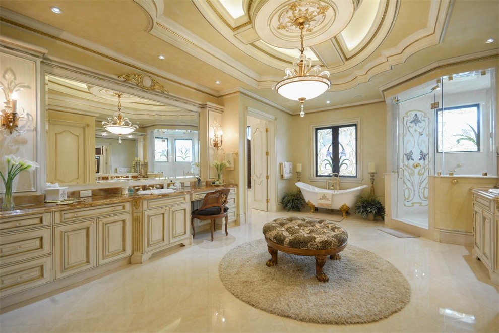 Bathroom - huge mediterranean master marble floor bathroom idea in Miami with raised-panel cabinets, yellow cabinets, yellow walls, a trough sink, granite countertops and a hinged shower door