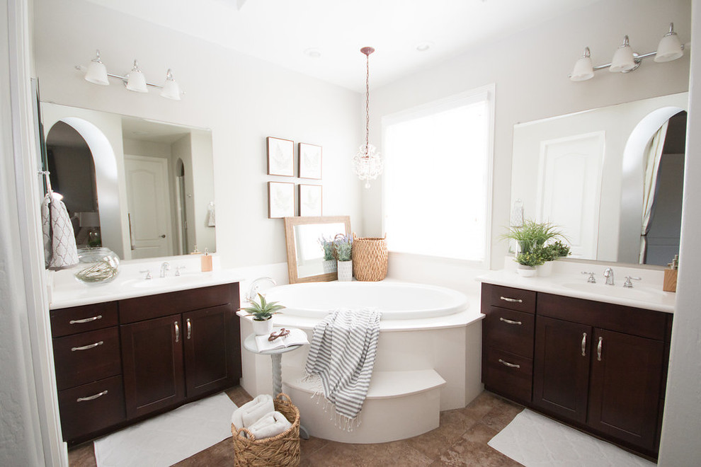 Example of a mid-sized tuscan master gray tile ceramic tile and beige floor drop-in bathtub design in Phoenix with shaker cabinets, brown cabinets, gray walls and solid surface countertops