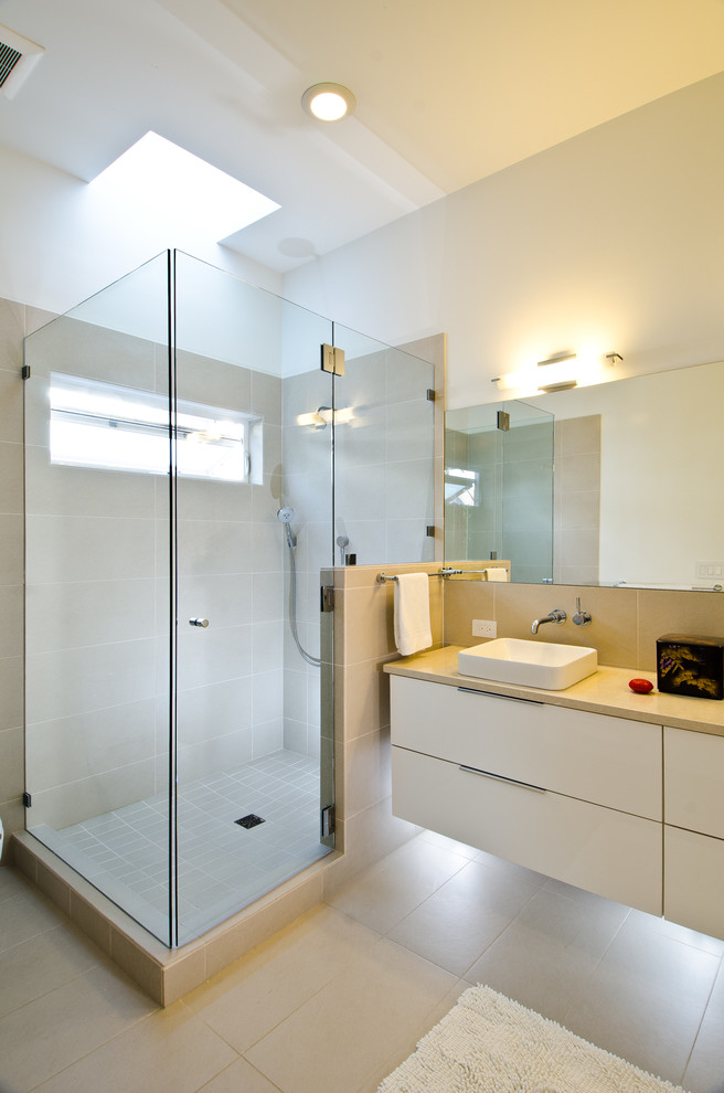 Inspiration for a mid-sized modern master porcelain tile porcelain tile doorless shower remodel in Seattle with flat-panel cabinets, white cabinets, a two-piece toilet, white walls, a vessel sink and quartz countertops