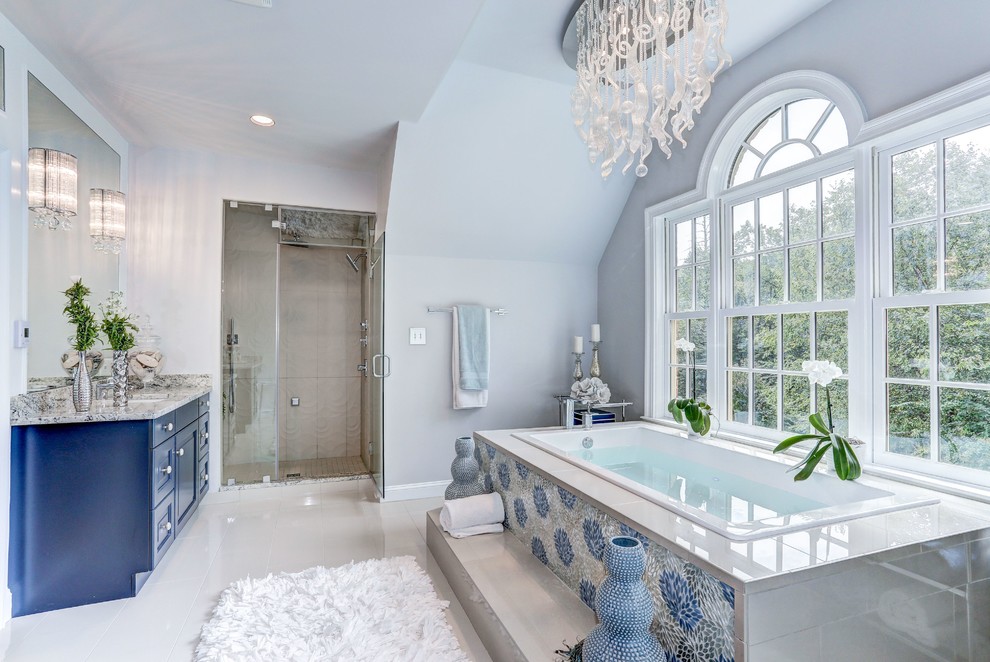 Design ideas for a large contemporary ensuite bathroom in DC Metro with raised-panel cabinets, blue cabinets, a freestanding bath, grey walls, a submerged sink, a hinged door and multi-coloured worktops.