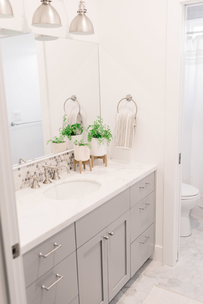 Klassisk inredning av ett mellanstort badrum för barn, med skåp i shakerstil, grå skåp, ett badkar i en alkov, en dusch/badkar-kombination, grå kakel, mosaik, vita väggar, marmorgolv, ett undermonterad handfat, marmorbänkskiva och dusch med duschdraperi