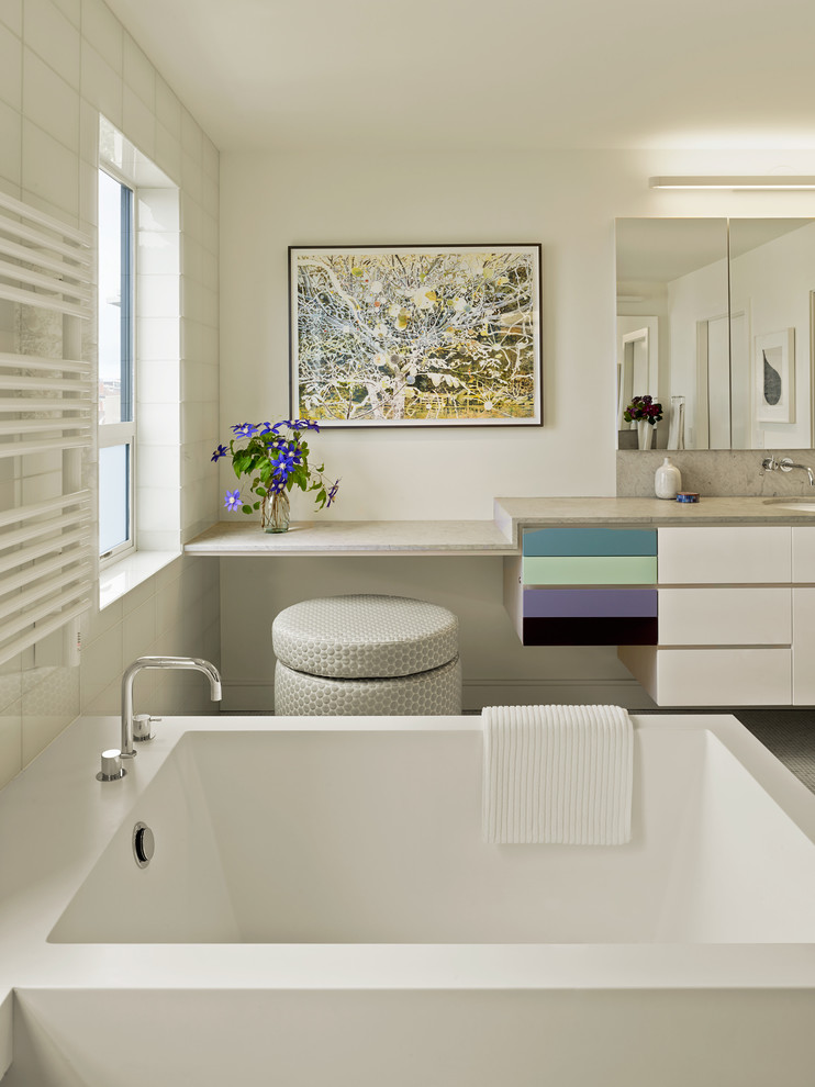 Идея дизайна: ванная комната среднего размера в современном стиле с врезной раковиной, плоскими фасадами, белыми фасадами, отдельно стоящей ванной, белыми стенами, унитазом-моноблоком, серой плиткой, плиткой мозаикой, полом из мозаичной плитки и столешницей из гранита