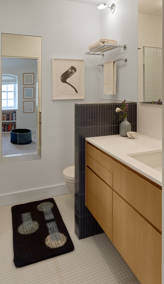 Exempel på ett mellanstort modernt badrum för barn, med släta luckor, skåp i ljust trä, en toalettstol med hel cisternkåpa, blå kakel, glaskakel, blå väggar, klinkergolv i keramik, ett undermonterad handfat och bänkskiva i kvarts