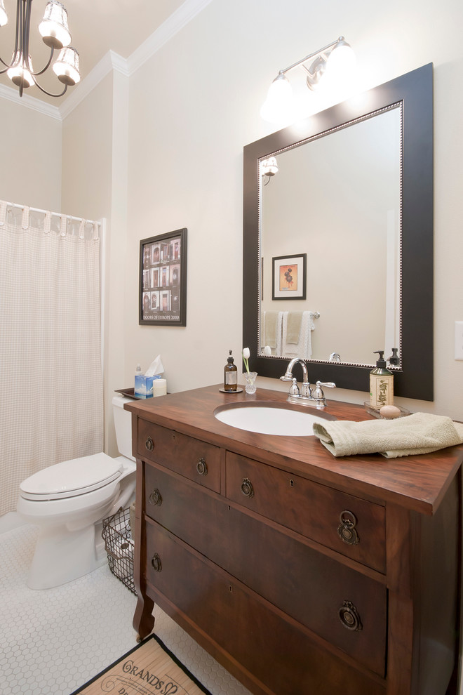 Foto på ett litet vintage badrum med dusch, med ett nedsänkt handfat, möbel-liknande, skåp i mellenmörkt trä, träbänkskiva och beige väggar