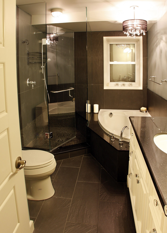 Elegant corner bathtub photo in Toronto with granite countertops and an undermount sink