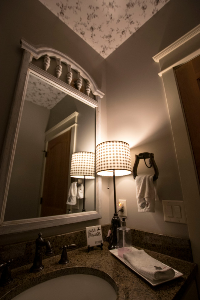 Foto på ett litet lantligt svart badrum med dusch, med möbel-liknande, bruna skåp, en toalettstol med hel cisternkåpa, beige väggar, mörkt trägolv, ett undermonterad handfat, granitbänkskiva och brunt golv