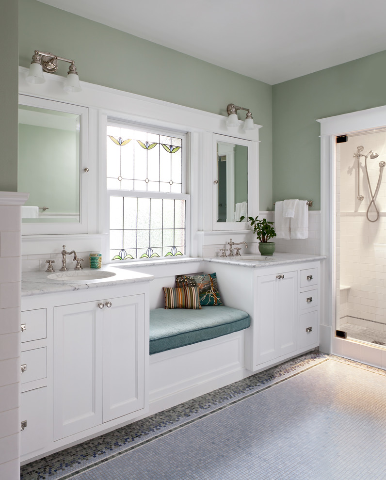 Foto de cuarto de baño clásico con armarios con paneles empotrados, puertas de armario blancas, baldosas y/o azulejos blancos, paredes verdes, suelo con mosaicos de baldosas, lavabo bajoencimera y espejo con luz