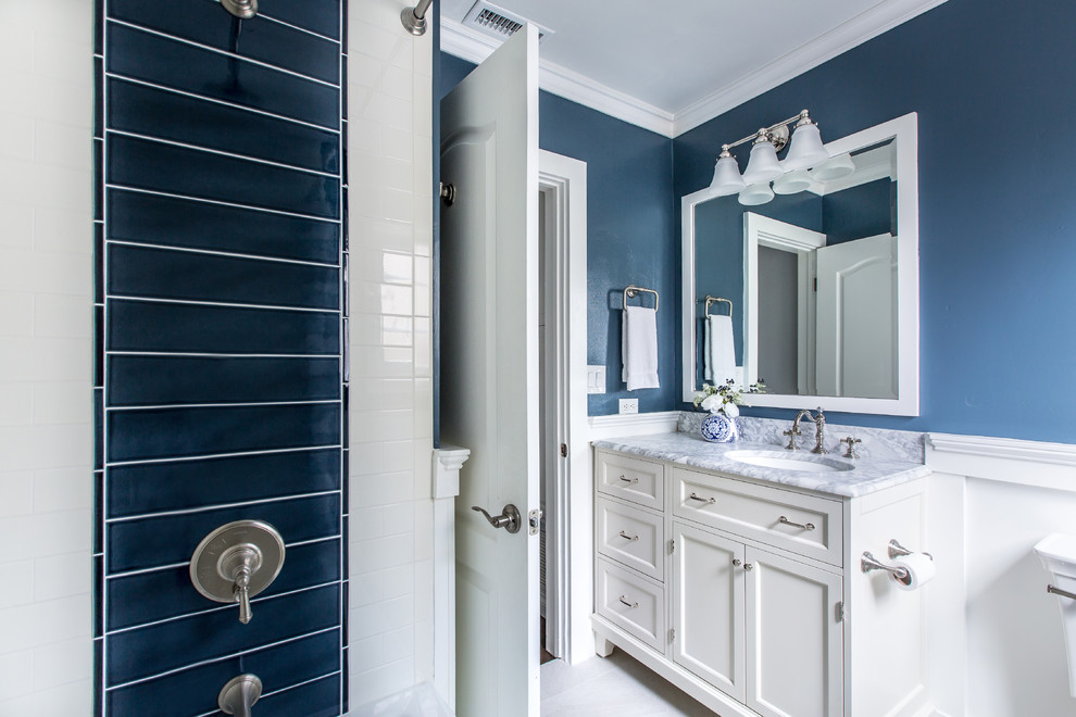 На фото: ванная комната в классическом стиле с фасадами с утопленной филенкой, белыми фасадами, синей плиткой, белой плиткой, синими стенами, врезной раковиной, серым полом, шторкой для ванной и белой столешницей