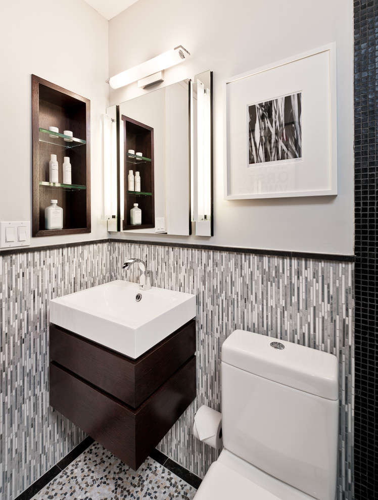 Foto på ett litet funkis en-suite badrum, med ett väggmonterat handfat, släta luckor, skåp i mörkt trä, en öppen dusch, en toalettstol med hel cisternkåpa, svart kakel, mosaik, grå väggar och marmorgolv