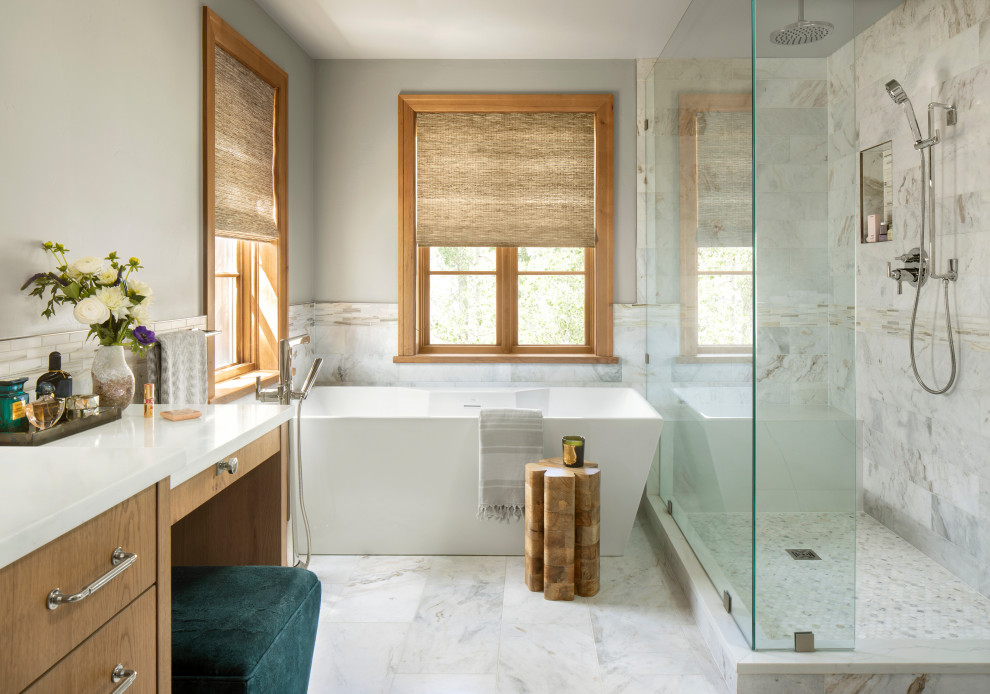 Идея дизайна: большая главная ванная комната в стиле рустика с плоскими фасадами, фасадами цвета дерева среднего тона, отдельно стоящей ванной, угловым душем, унитазом-моноблоком, белой плиткой, мраморной плиткой, серыми стенами, мраморным полом, врезной раковиной, столешницей из искусственного кварца, белым полом, душем с распашными дверями, белой столешницей, сиденьем для душа, тумбой под две раковины, встроенной тумбой и панелями на стенах