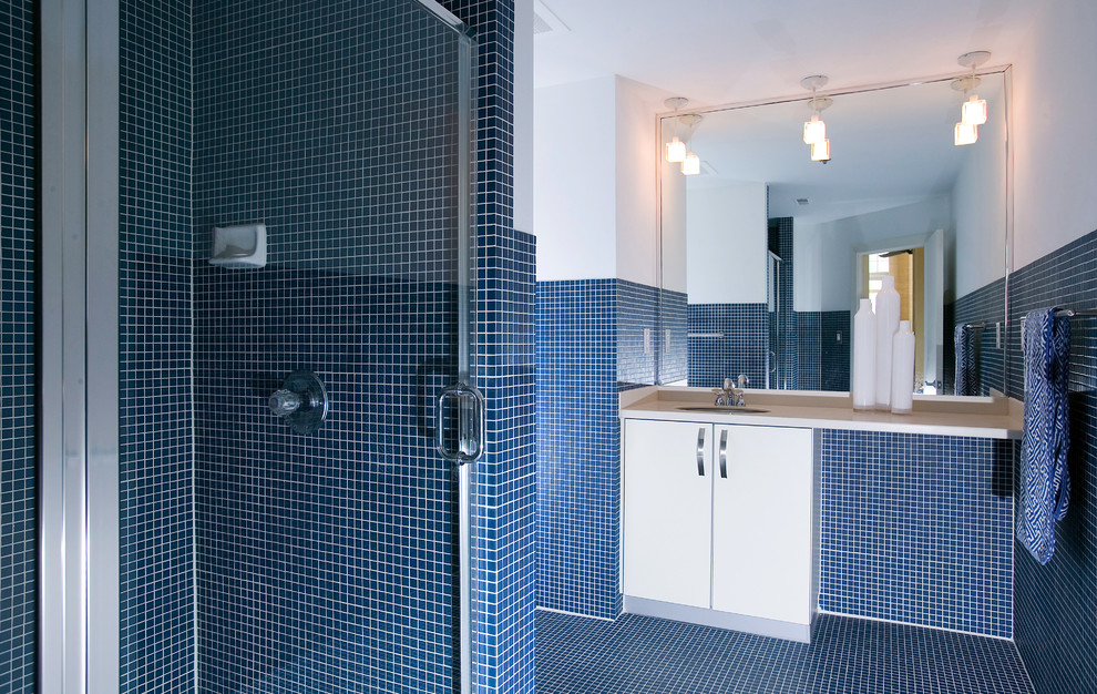 Inspiration för moderna badrum med dusch, med ett undermonterad handfat, släta luckor, vita skåp, en dusch i en alkov, blå kakel och vita väggar