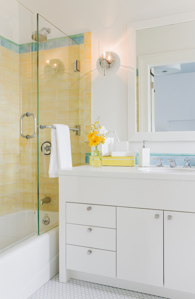 Идея дизайна: ванная комната среднего размера в стиле модернизм с врезной раковиной, плоскими фасадами, белыми фасадами, ванной в нише, душем над ванной, желтой плиткой, плиткой кабанчик, белыми стенами, полом из керамической плитки, душевой кабиной, столешницей из искусственного кварца и белым полом