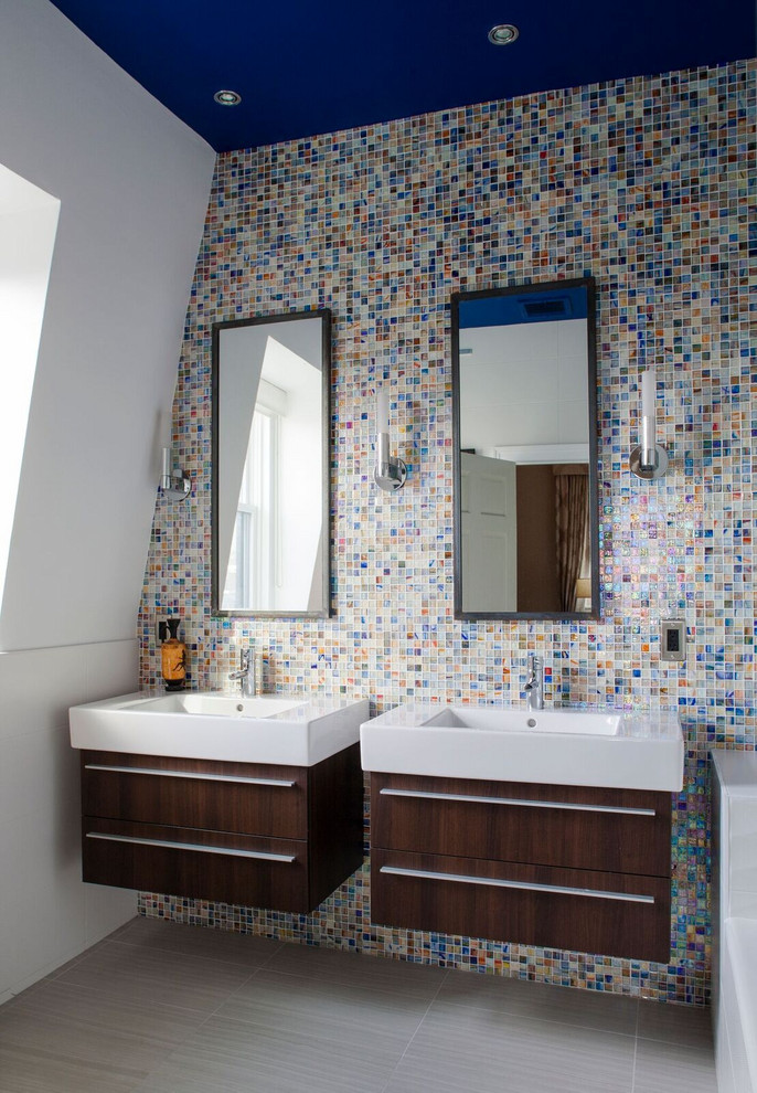 Diseño de cuarto de baño actual con armarios con paneles lisos, puertas de armario de madera en tonos medios, baldosas y/o azulejos multicolor, baldosas y/o azulejos en mosaico, paredes blancas, lavabo tipo consola y suelo gris
