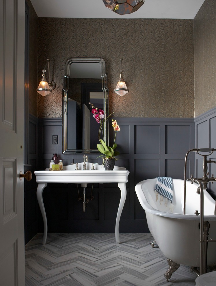 Imagen de cuarto de baño tradicional de tamaño medio con bañera con patas, paredes grises, lavabo tipo consola, suelo laminado y aseo y ducha