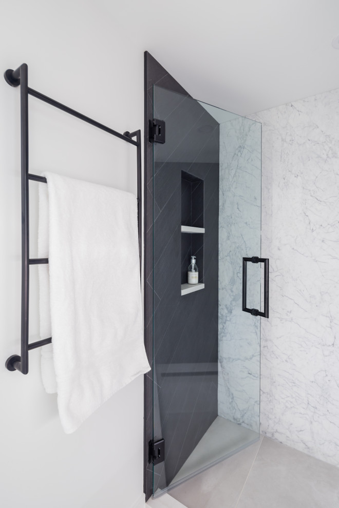 На фото: маленькая главная ванная комната в современном стиле с плоскими фасадами, белыми фасадами, душем в нише, унитазом-моноблоком, черной плиткой, керамической плиткой, белыми стенами, полом из керамогранита, врезной раковиной, столешницей из искусственного кварца, серым полом, душем с распашными дверями, белой столешницей, тумбой под одну раковину, встроенной тумбой и нишей для на участке и в саду