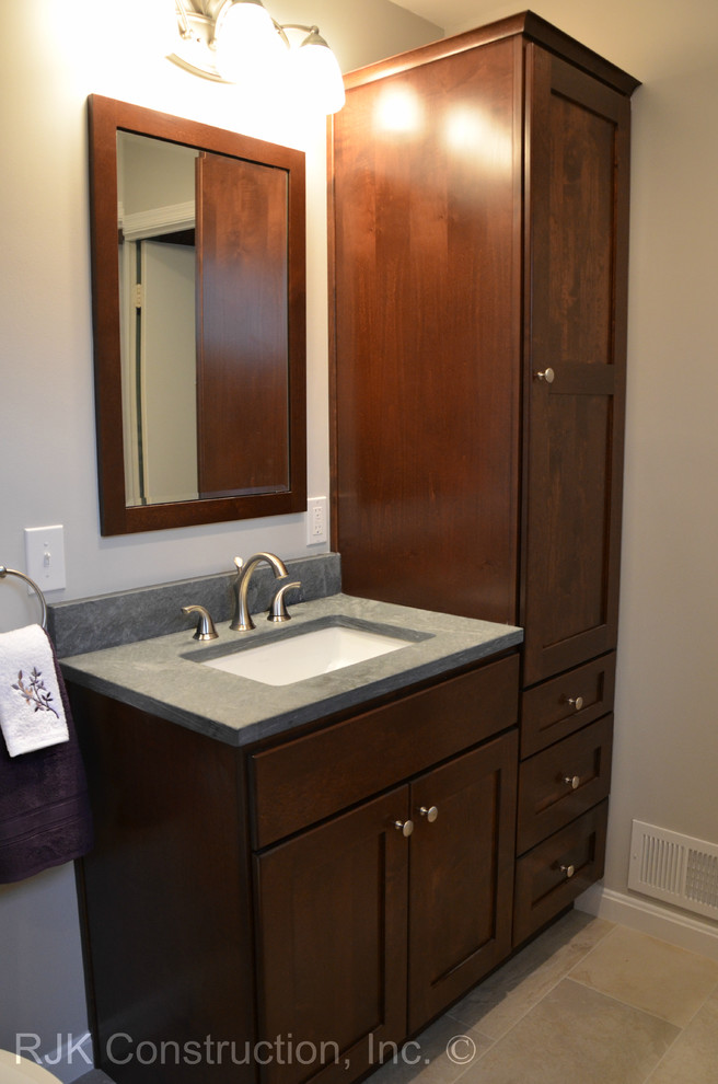 Modern inredning av ett mellanstort en-suite badrum, med ett undermonterad handfat, skåp i shakerstil, skåp i mörkt trä, ett platsbyggt badkar, en dusch/badkar-kombination, en toalettstol med separat cisternkåpa, grå kakel, stenkakel och vita väggar