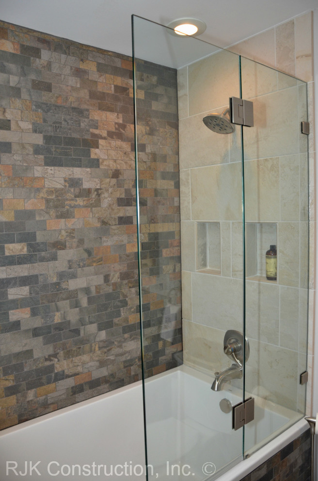 Medium sized contemporary ensuite bathroom in DC Metro with a submerged sink, shaker cabinets, dark wood cabinets, a built-in bath, a shower/bath combination, a two-piece toilet, grey tiles, stone tiles and white walls.