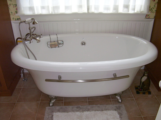 Example of a mid-sized classic 3/4 brown tile ceramic tile claw-foot bathtub design in New York with a pedestal sink, raised-panel cabinets, medium tone wood cabinets and multicolored walls
