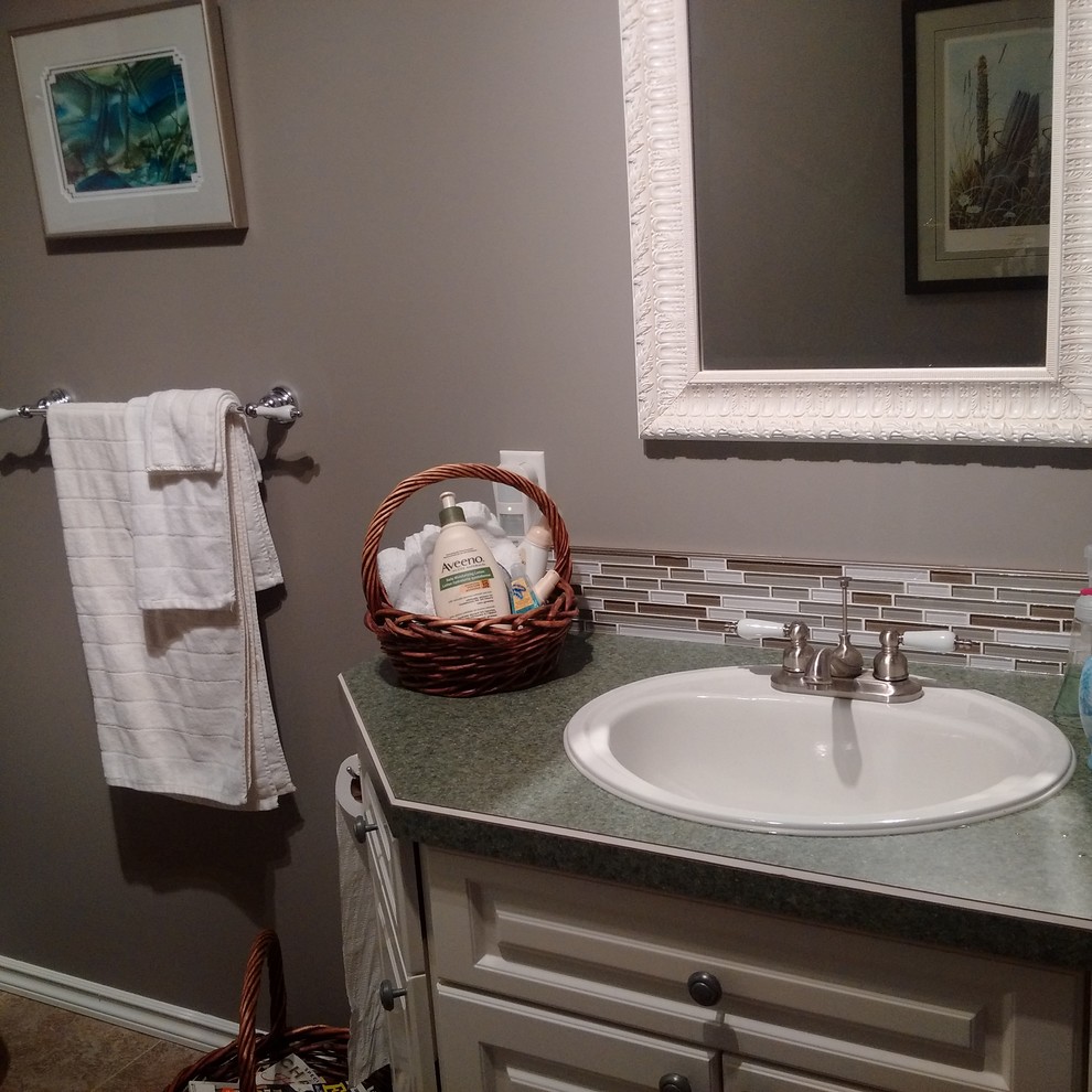 Kleines Klassisches Badezimmer En Suite mit farbigen Fliesen, Fliesen aus Glasscheiben, grauer Wandfarbe, profilierten Schrankfronten, weißen Schränken, Einbauwaschbecken und Laminat-Waschtisch in Sonstige