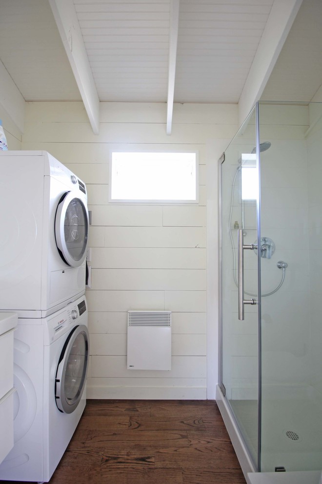 This is an example of a small nautical shower room bathroom in Seattle with flat-panel cabinets, white cabinets, a corner shower, a one-piece toilet, white walls, dark hardwood flooring, a wall-mounted sink, brown floors and a hinged door.