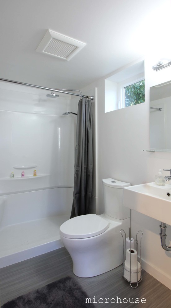 Ejemplo de cuarto de baño contemporáneo pequeño con ducha empotrada, sanitario de dos piezas, paredes blancas, suelo de linóleo, aseo y ducha y lavabo suspendido