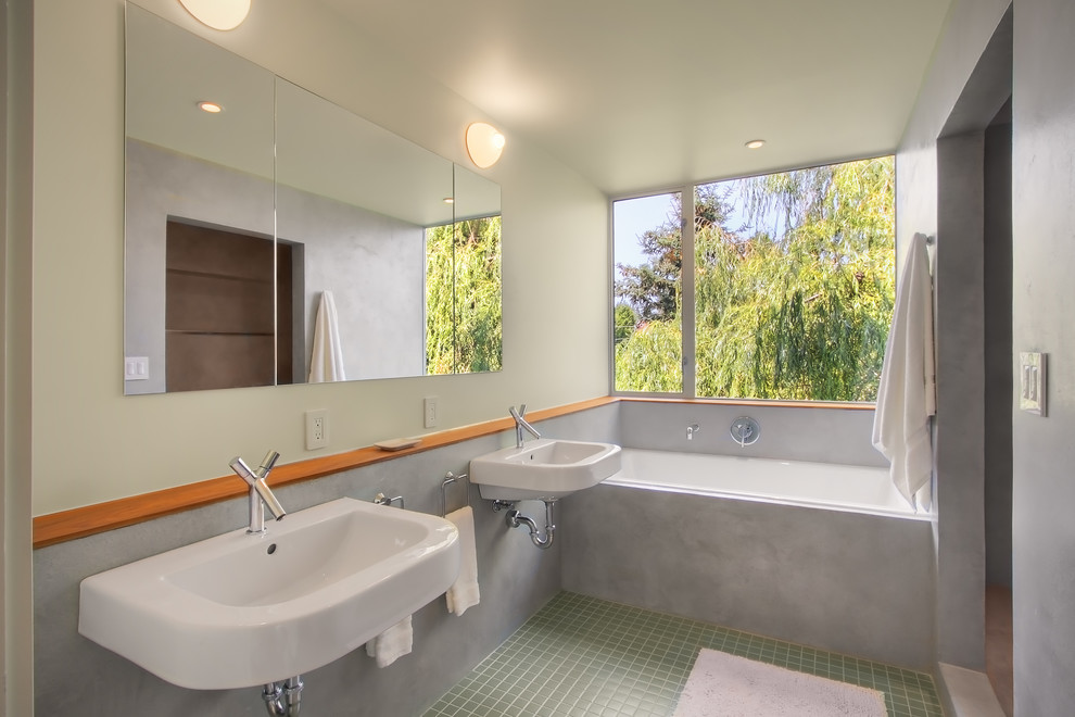 Cette image montre une salle de bain principale minimaliste de taille moyenne avec un lavabo suspendu, une baignoire en alcôve, une douche ouverte, un mur beige, un sol en carrelage de terre cuite, aucune cabine et un sol vert.