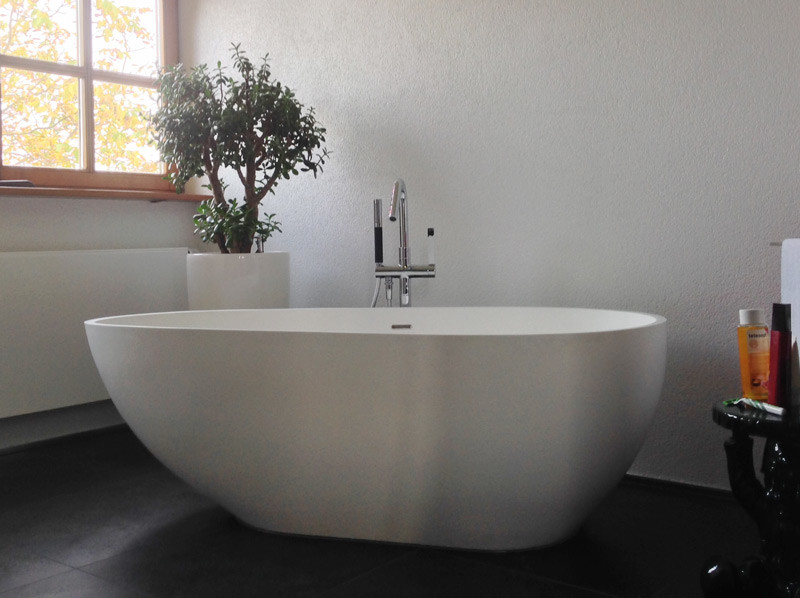 Cette image montre une salle de bain principale minimaliste de taille moyenne avec une baignoire indépendante.