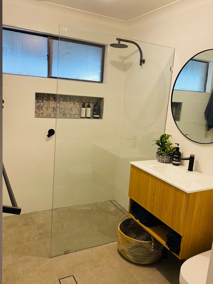 Inredning av ett modernt litet vit vitt badrum, med bruna skåp, en öppen dusch, en toalettstol med hel cisternkåpa, vit kakel, porslinskakel, vita väggar, klinkergolv i porslin, ett integrerad handfat, bänkskiva i akrylsten, grått golv och med dusch som är öppen