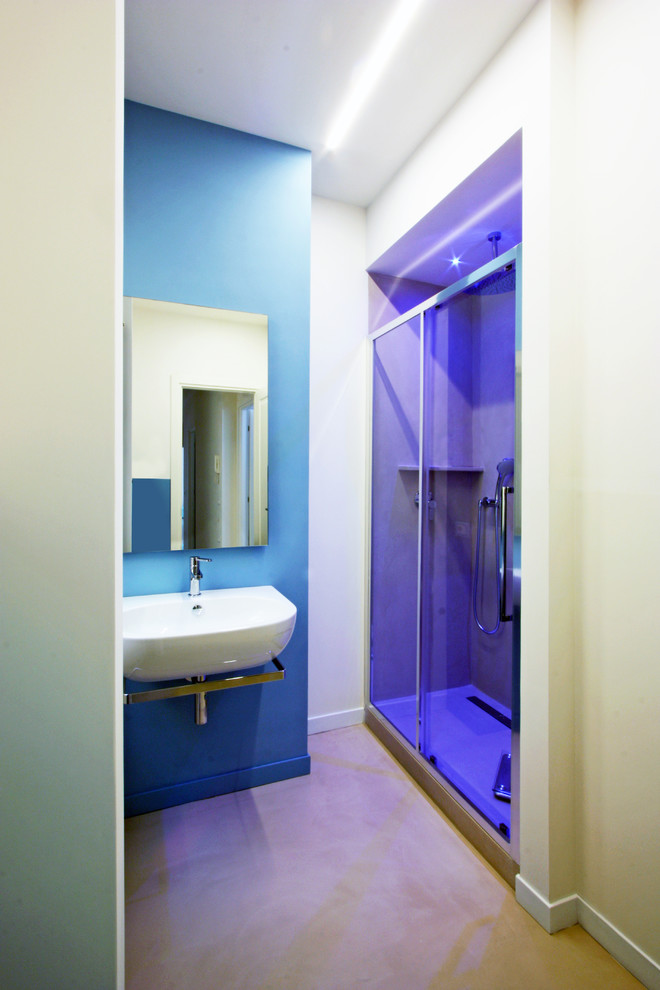 Ispirazione per una stanza da bagno padronale design di medie dimensioni con lavabo a consolle, doccia alcova, WC sospeso, piastrelle multicolore, pareti blu e pavimento in cemento