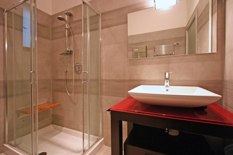 Exemple d'une salle de bain principale tendance en bois foncé de taille moyenne avec un lavabo posé, un placard en trompe-l'oeil, un plan de toilette en verre, une baignoire posée, une douche d'angle, WC suspendus, un carrelage gris, des carreaux de céramique, un mur gris et sol en béton ciré.
