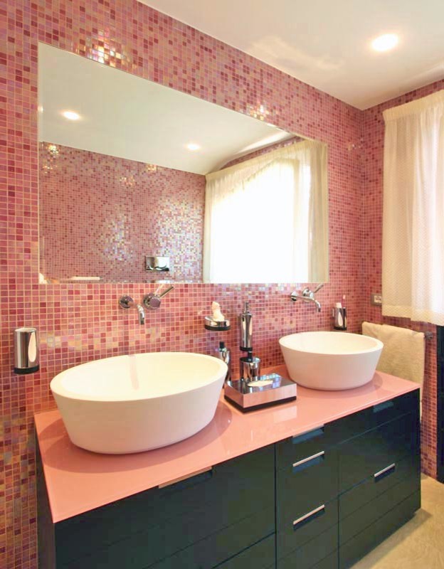 Foto på ett stort eklektiskt badrum för barn, med ett nedsänkt handfat, möbel-liknande, skåp i mörkt trä, bänkskiva i glas, en hörndusch, en vägghängd toalettstol, rosa kakel, mosaik, rosa väggar och klinkergolv i keramik