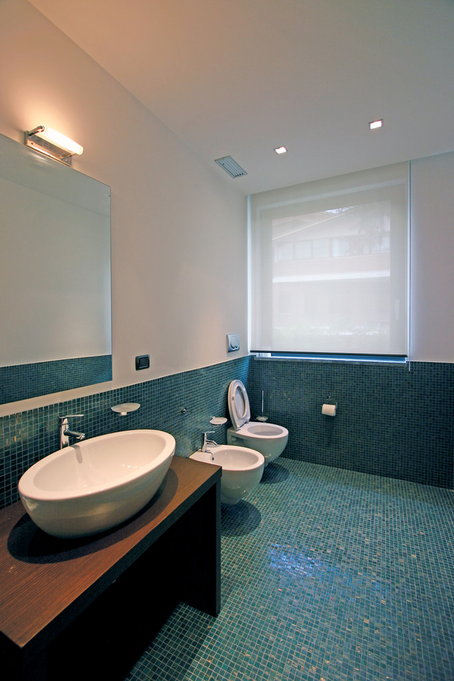 На фото: ванная комната среднего размера в стиле модернизм с накладной раковиной, фасадами островного типа, фасадами цвета дерева среднего тона, столешницей из дерева, душем в нише, инсталляцией, зеленой плиткой, плиткой мозаикой, полом из мозаичной плитки, душевой кабиной и синими стенами с