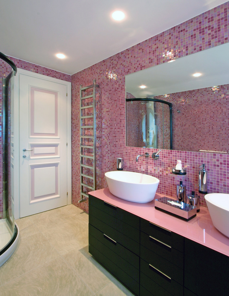 Exempel på ett mellanstort modernt badrum för barn, med skåp i mörkt trä, bänkskiva i glas, en hörndusch, en vägghängd toalettstol, rosa kakel, mosaik, rosa väggar, klinkergolv i keramik, ett fristående handfat och släta luckor