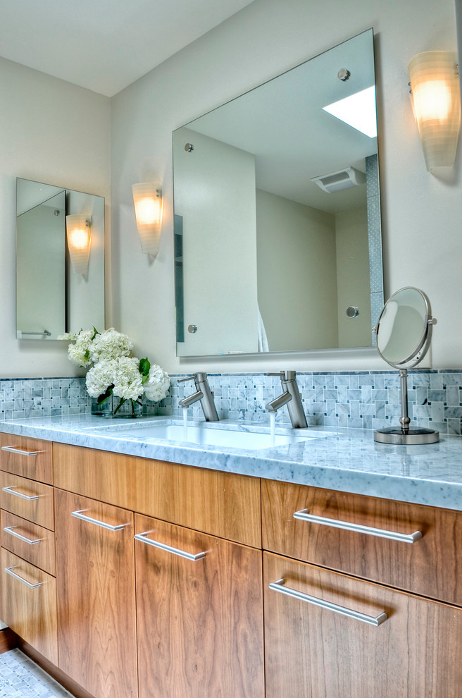 Cette image montre une petite salle d'eau traditionnelle en bois brun avec un lavabo encastré, un placard à porte plane, un plan de toilette en marbre, un carrelage gris, mosaïque, un mur gris, un sol en marbre et un plan de toilette gris.