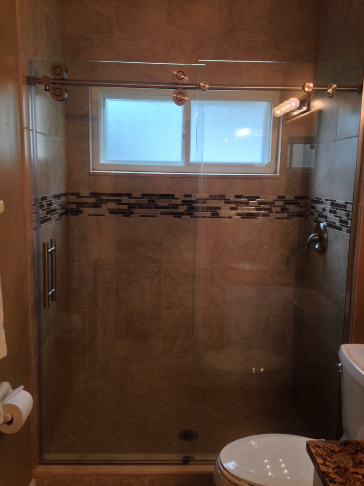 Bathroom - large traditional beige tile and porcelain tile porcelain tile bathroom idea in Jacksonville with flat-panel cabinets, granite countertops, a two-piece toilet and an undermount sink