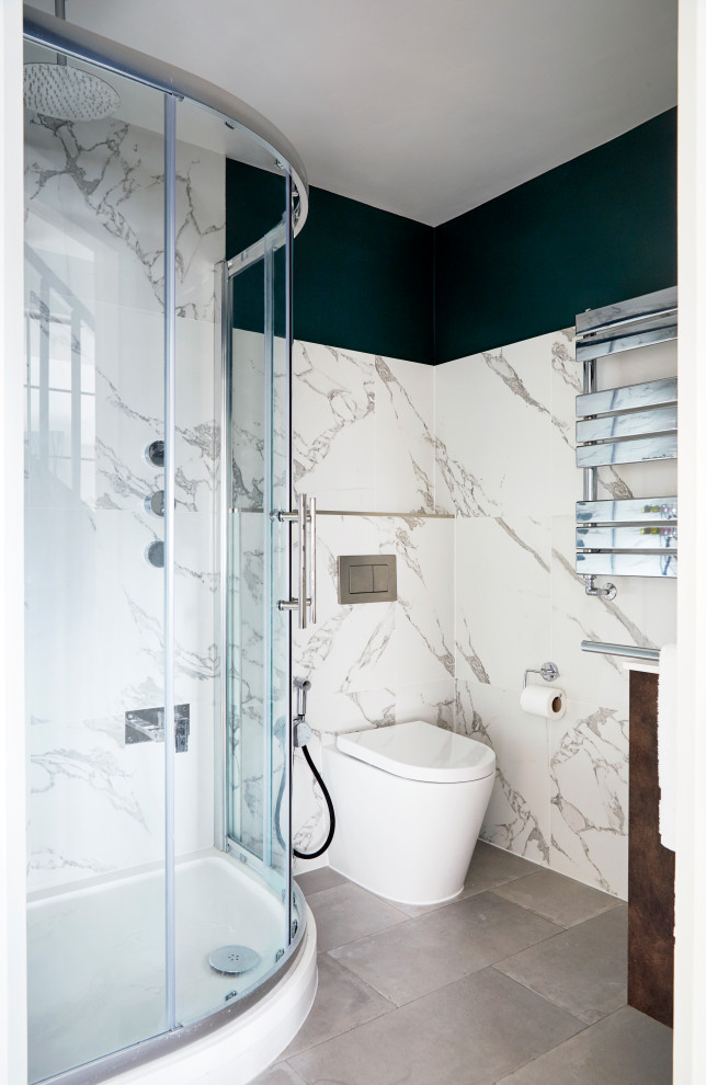 Corner shower - small contemporary master white tile and porcelain tile porcelain tile, gray floor and single-sink corner shower idea in London with flat-panel cabinets, white cabinets, solid surface countertops, a hinged shower door and a floating vanity