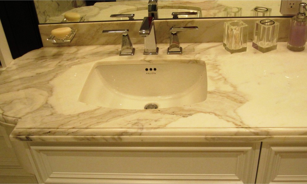 Foto di una stanza da bagno padronale moderna di medie dimensioni con ante con riquadro incassato, ante bianche, lavabo sottopiano, top in marmo e top grigio