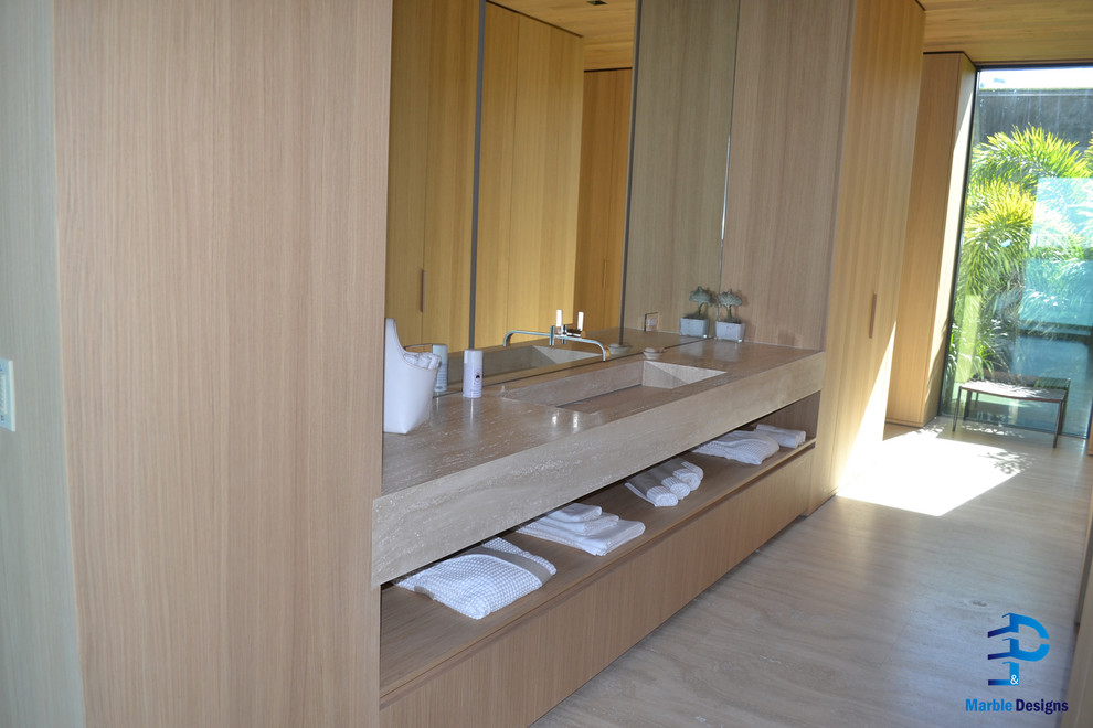 Modern inredning av ett en-suite badrum, med släta luckor, skåp i ljust trä, en jacuzzi, en dusch/badkar-kombination, beige kakel, stenhäll, beige väggar, marmorgolv, ett integrerad handfat och marmorbänkskiva