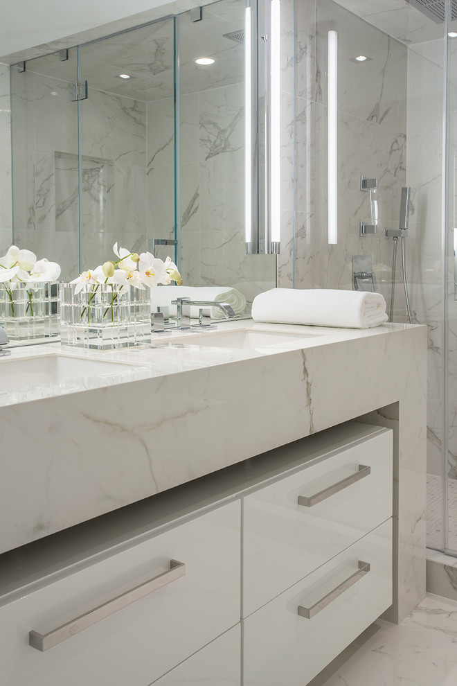 Immagine di una stanza da bagno padronale minimalista di medie dimensioni con ante lisce, ante bianche, doccia alcova, piastrelle grigie, lastra di pietra, pareti bianche e lavabo sottopiano