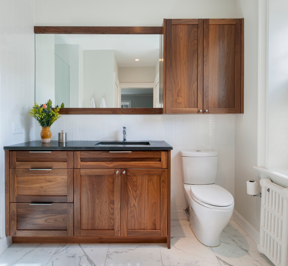 Inspiration for a mid-sized transitional 3/4 white tile and subway tile marble floor and white floor bathroom remodel in Philadelphia with shaker cabinets, medium tone wood cabinets, a two-piece toilet, white walls, an undermount sink, granite countertops and a hinged shower door