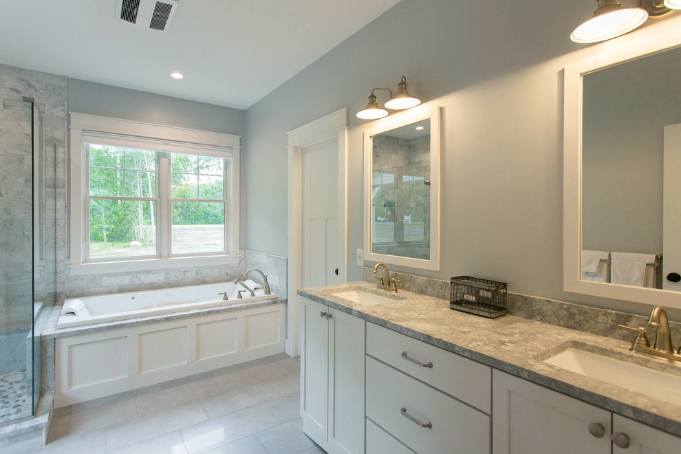 Klassisk inredning av ett stort en-suite badrum, med skåp i shakerstil, vita skåp, ett platsbyggt badkar, en hörndusch, grå kakel, marmorkakel, grå väggar, klinkergolv i keramik, ett undermonterad handfat, granitbänkskiva, grått golv och dusch med gångjärnsdörr