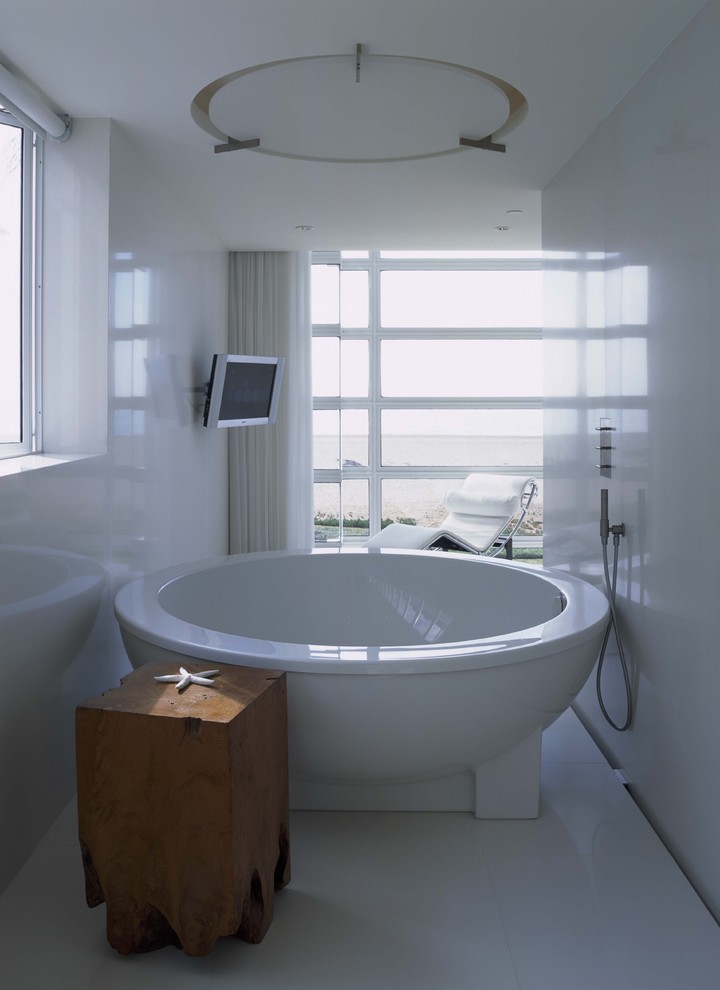 Foto på ett funkis badrum, med ett fristående badkar och vit kakel