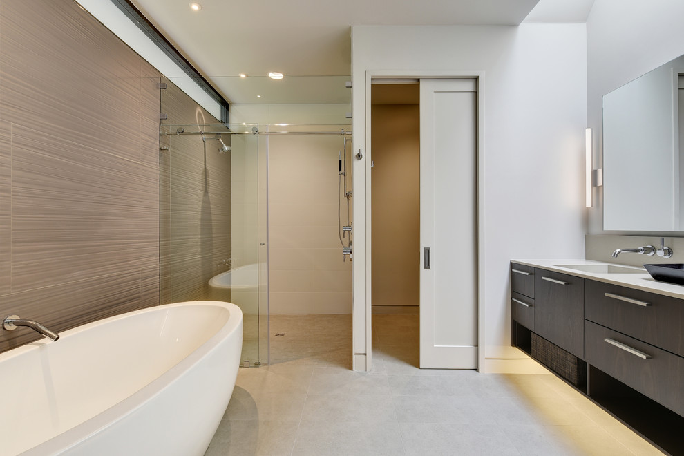 Design ideas for a contemporary ensuite bathroom in Austin with flat-panel cabinets, dark wood cabinets, a freestanding bath, a built-in shower, beige tiles, beige walls, an integrated sink and a sliding door.