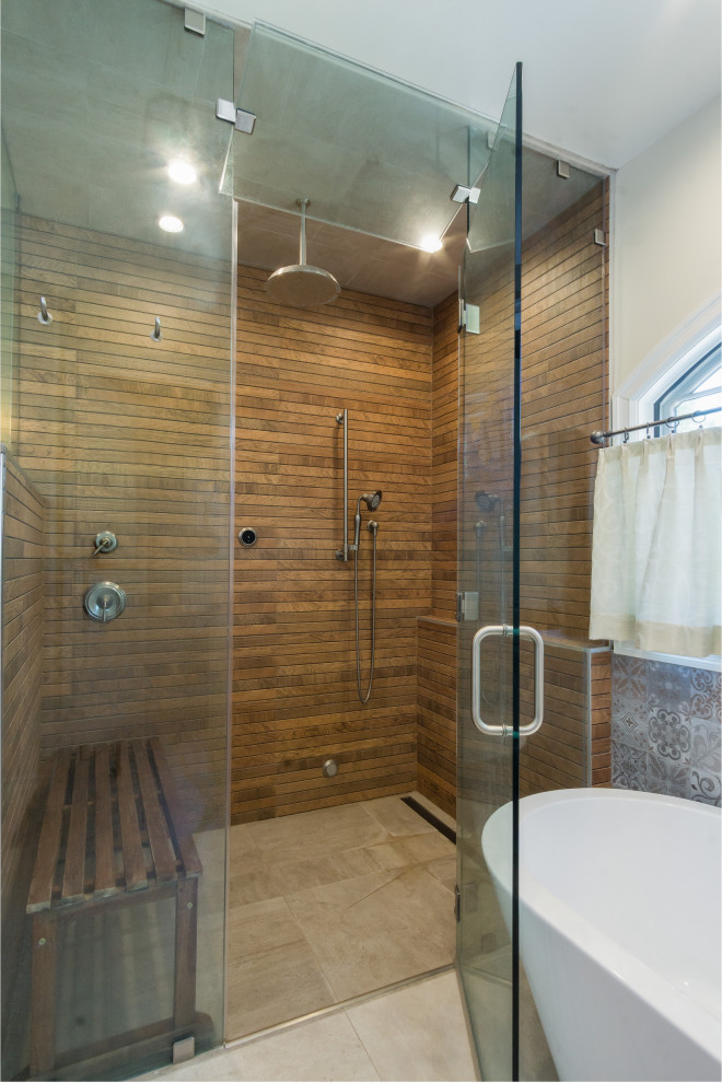 Medelhavsstil inredning av ett stort en-suite badrum, med ett fristående badkar, en kantlös dusch, brun kakel, porslinskakel, beige väggar, klinkergolv i porslin, beiget golv och dusch med gångjärnsdörr