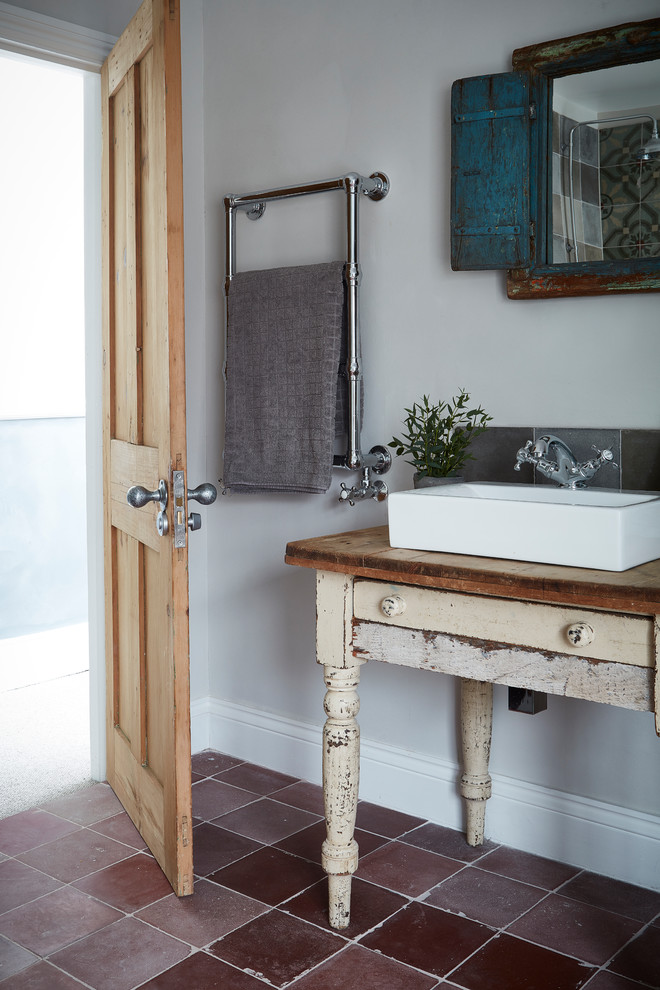Пример оригинального дизайна: ванная комната в стиле рустика с серыми стенами, полом из керамической плитки, настольной раковиной и красным полом