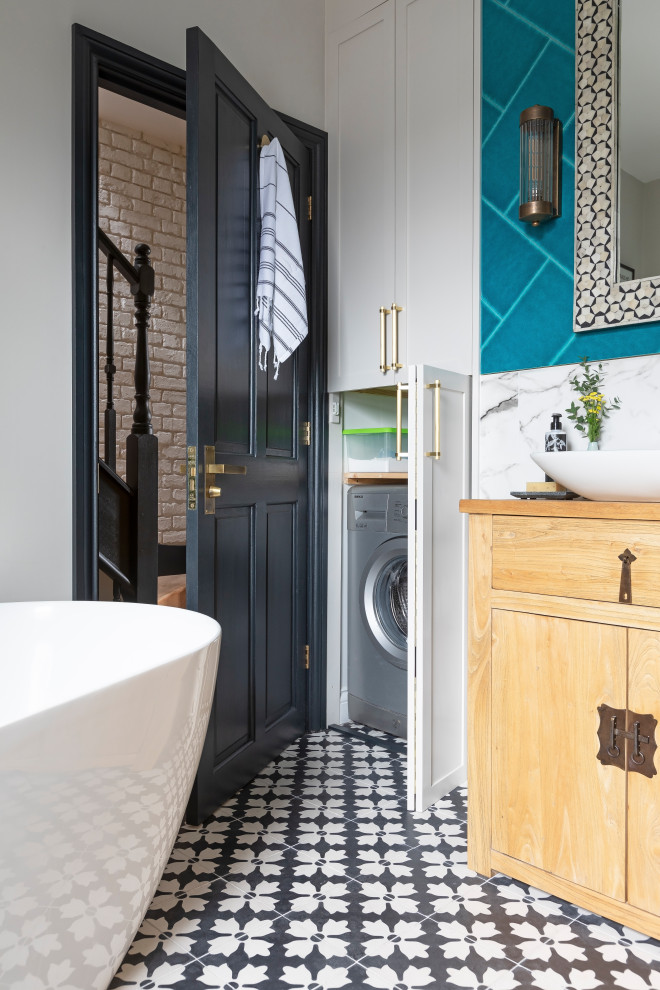 Medium sized traditional family bathroom in London with light wood cabinets, a freestanding bath, a walk-in shower, a wall mounted toilet, multi-coloured tiles, ceramic tiles, multi-coloured walls, cement flooring, a vessel sink, wooden worktops, black floors, an open shower, a wall niche, a single sink and a freestanding vanity unit.