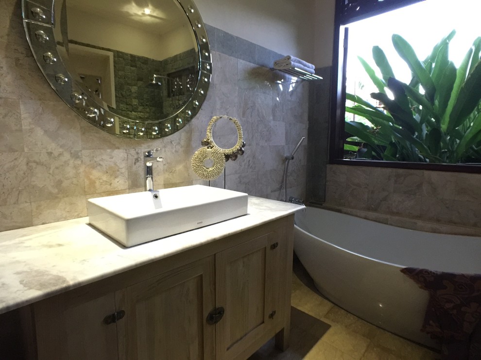 Diseño de cuarto de baño tropical con bañera exenta, ducha abierta, sanitario de una pieza, paredes beige, suelo de baldosas de cerámica, lavabo de seno grande, suelo beige y ducha abierta